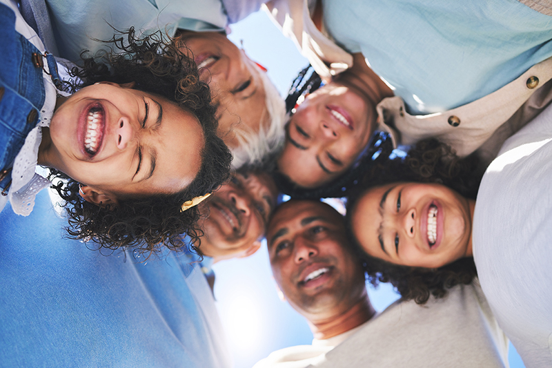 Happy family, face and smile in bonding, support or unity below together on weekend or summer vacation. Low angle of parents, grandparents and children huddle in happiness for fun holiday getaway