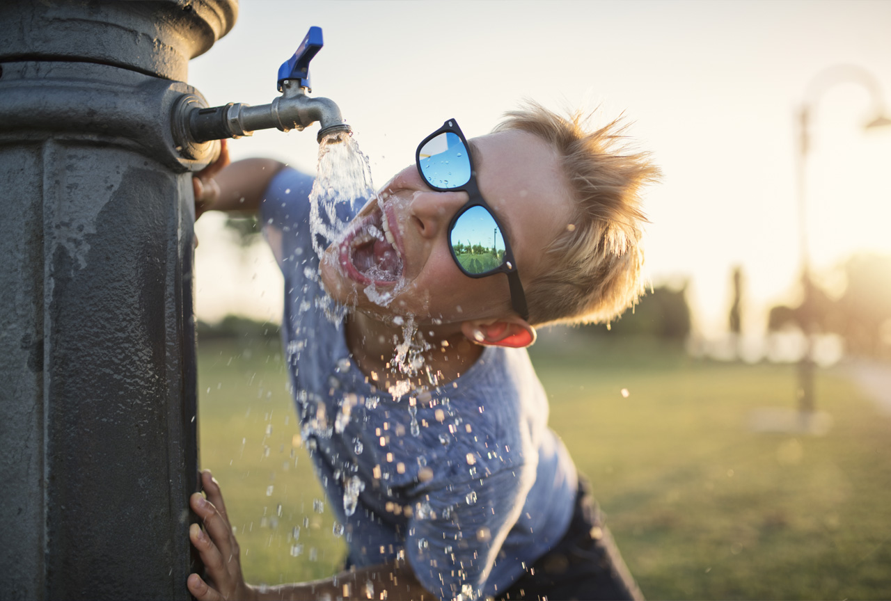 Young Boy Drinking from Community Water Faucet Funny